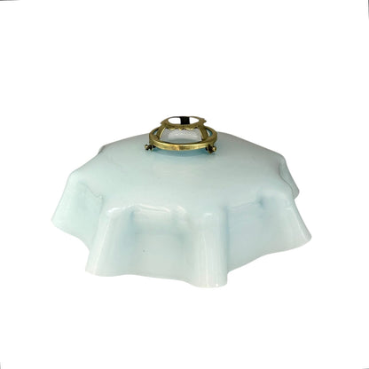 Vintage blue glass lamp shade with brass fitting on a white background