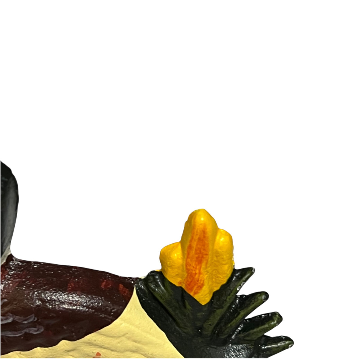 Close-up of a painted figurine door stop showing a dark brown and cream section, a black spiky detail, and a small yellow-orange flame-like accent on a plain white background.