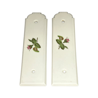 Pair of white door push plates with floral designs on a white background