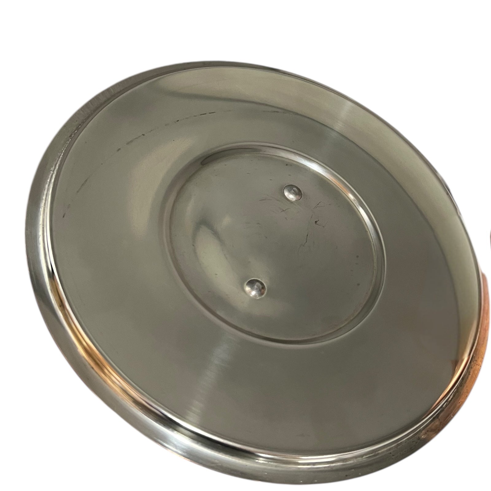 inside of copper pan lid  with tin lining on a white background