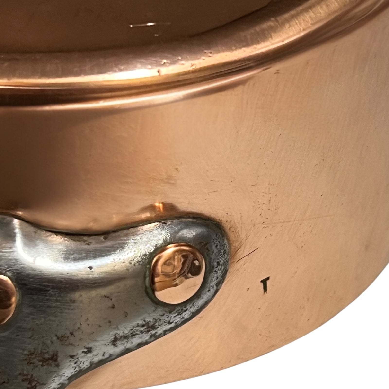 cast iron handle and copper rivets of copper pan