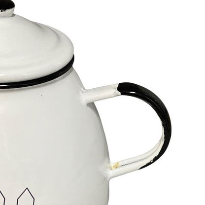 White enamel teapot with black handle and trim on a white background
