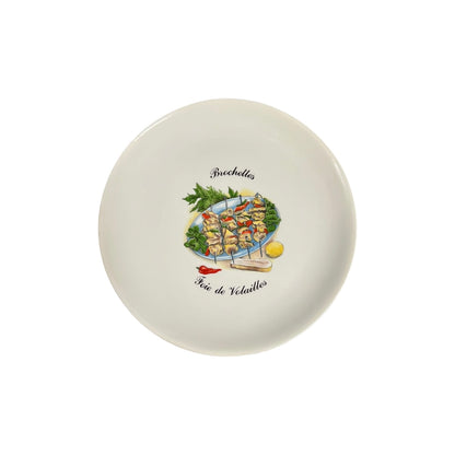Round ceramic plate with a decorative design of skewered vegetables and text on a white background