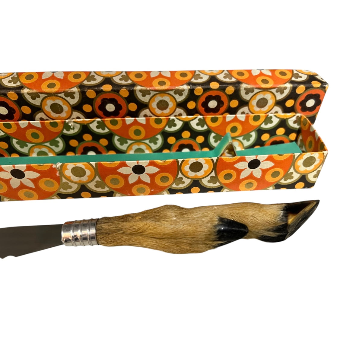 A decorative knife with a natural animal-hide handle and a silver metal bolster, displayed alongside its open patterned storage box on a white background.