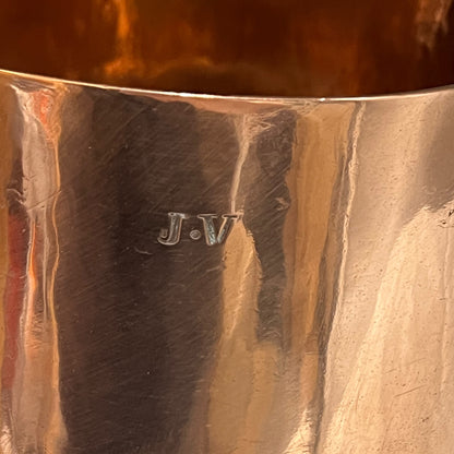 Close-up of a copper sugar pan with 'J.V.' engraving