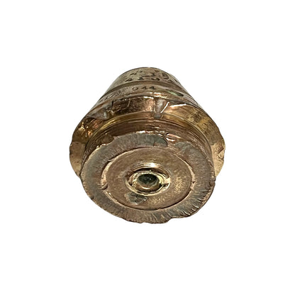 WW1 brass fuse paperweight with markings from use on a white background