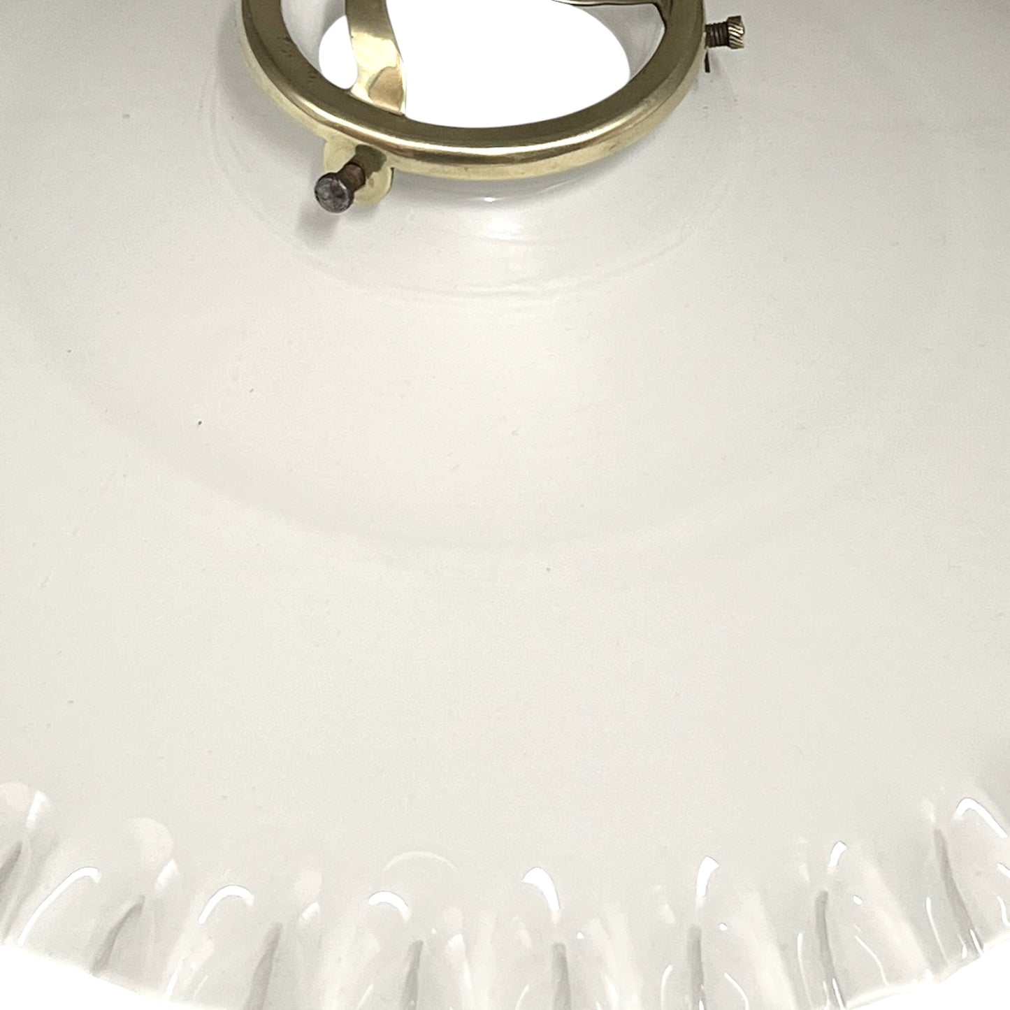 Close-up of a white lampshade with a gold ring on a white background