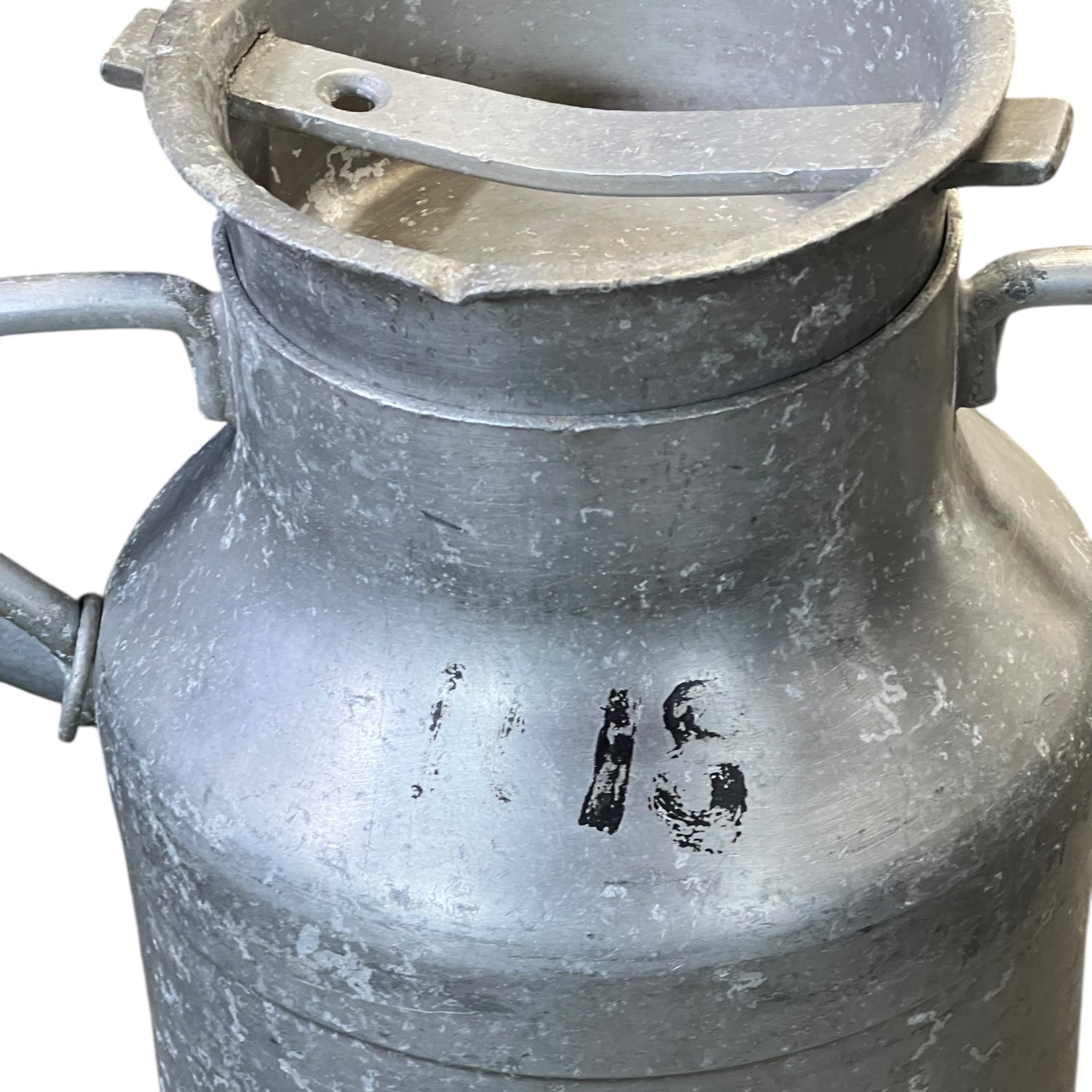 Vintage metal milk churn with visible wear and a number '16' on a white background