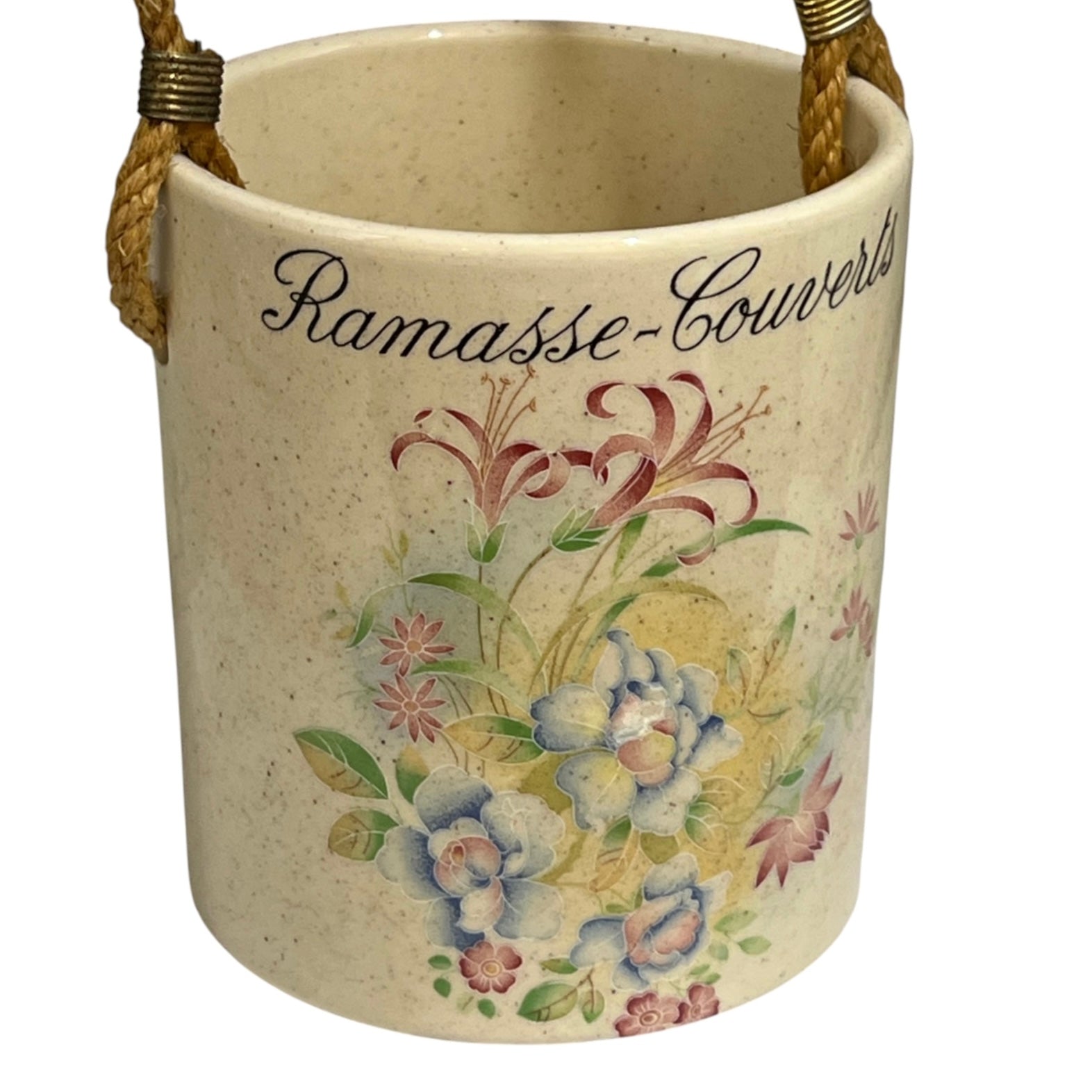 A vintage-style ceramic bucket with a speckled cream-beige finish, featuring a floral illustration and the cursive text 'Ramasse-Couverts' on the front. It has two braided rope handles with brass hardware, shown against a plain white background.