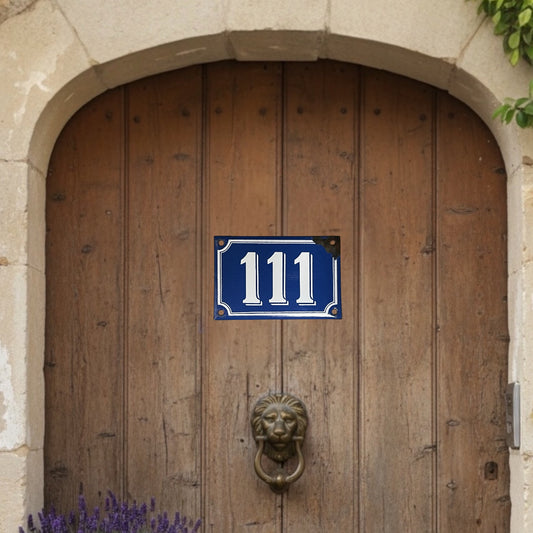 Wooden door with a blue house number sign '111' and a lion knocker.