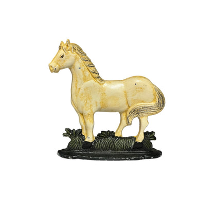 A small decorative horse door stay in a cream and yellow glaze, standing on a dark textured base with grass details, isolated on a white background.
