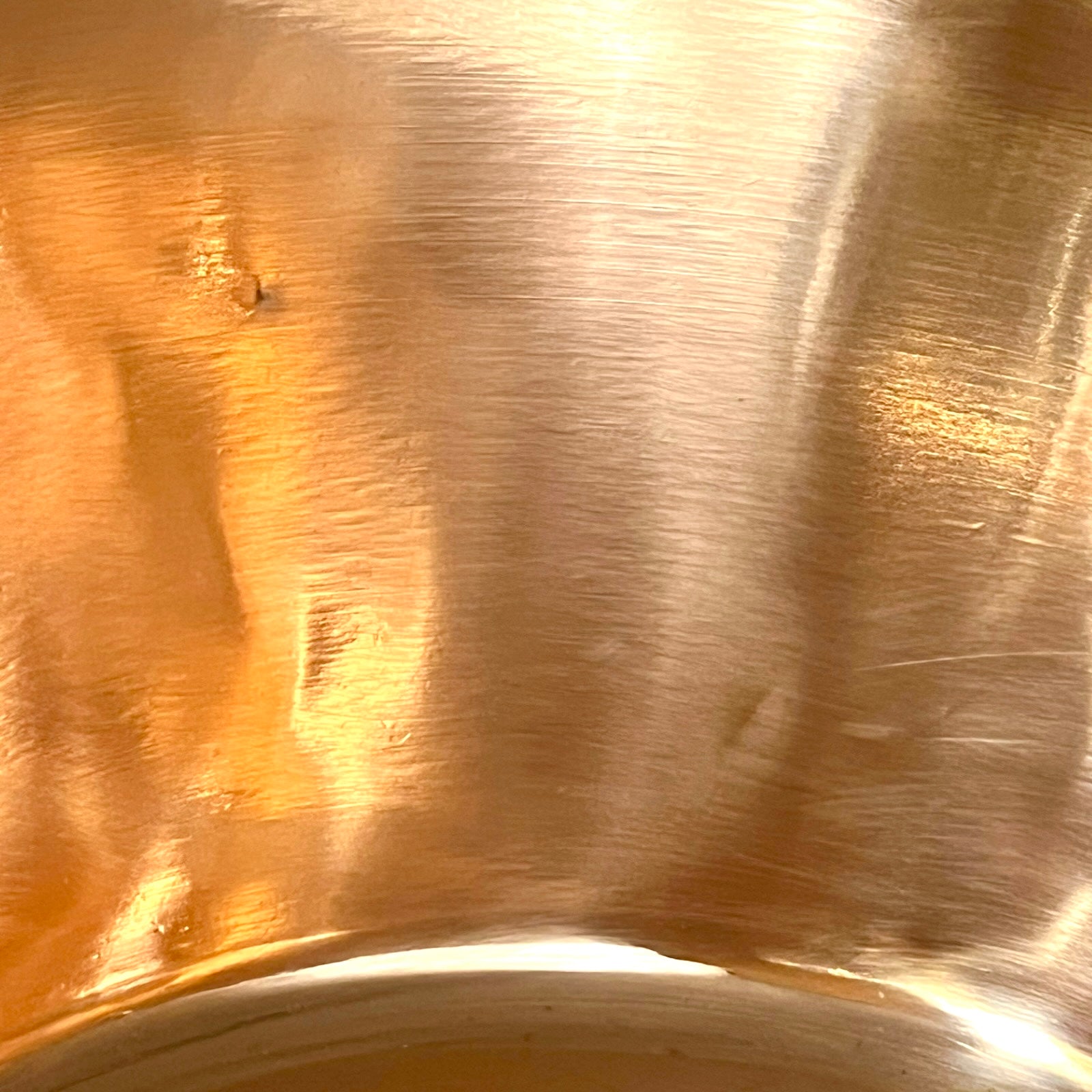 Close-up of a copper basin with a reflective finish on a white background 