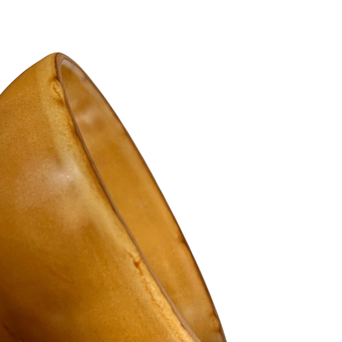 A close-up detail shot of a smooth, curved amber-brown storage jar, on a solid white background.