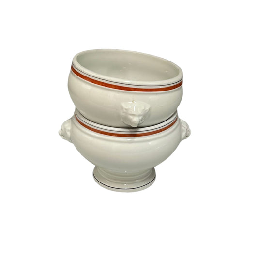 White ceramic footed bowl with lion head handles on a white background