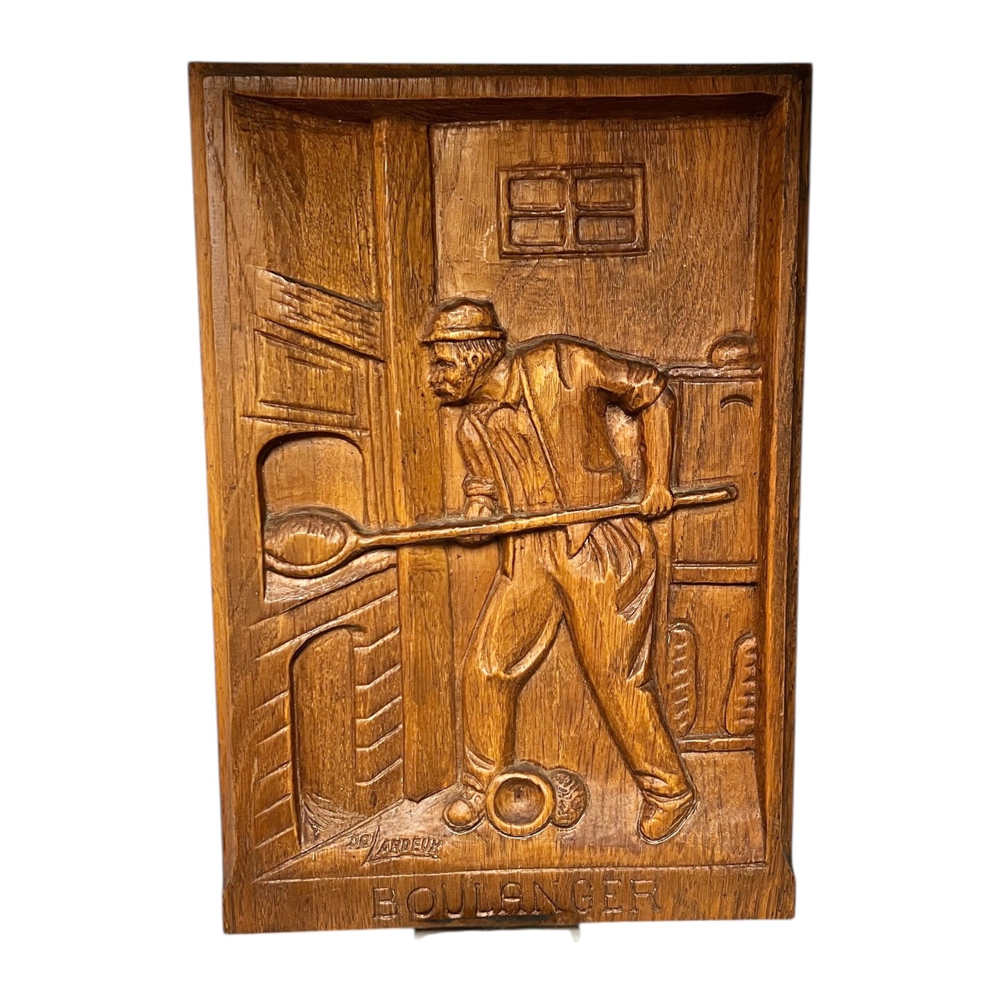 Wooden plaque with a carved scene of a man holding a club, on a white background