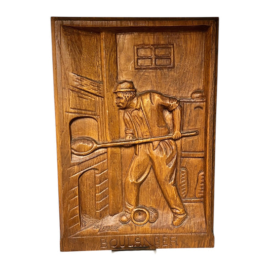 Wooden plaque with a carved scene of a man holding a club, on a white background