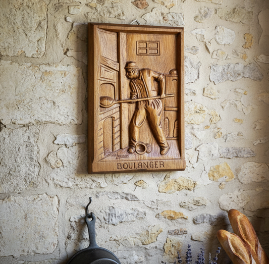 Wooden plaque with a bread baker design on a stone wall.