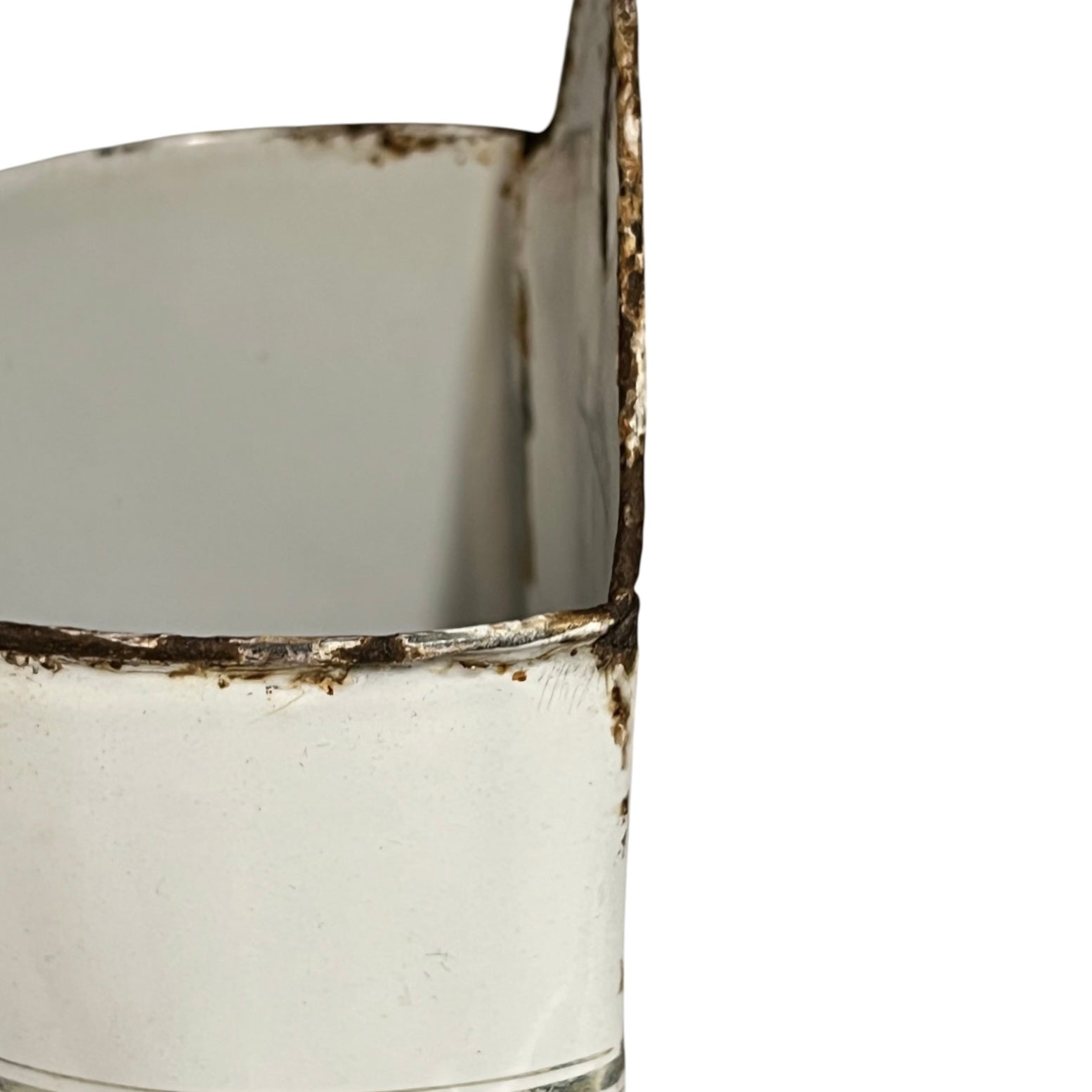 Close-up detail of a white metal container or cup with heavily distressed, rusted, and chipped edges against a plain white background.