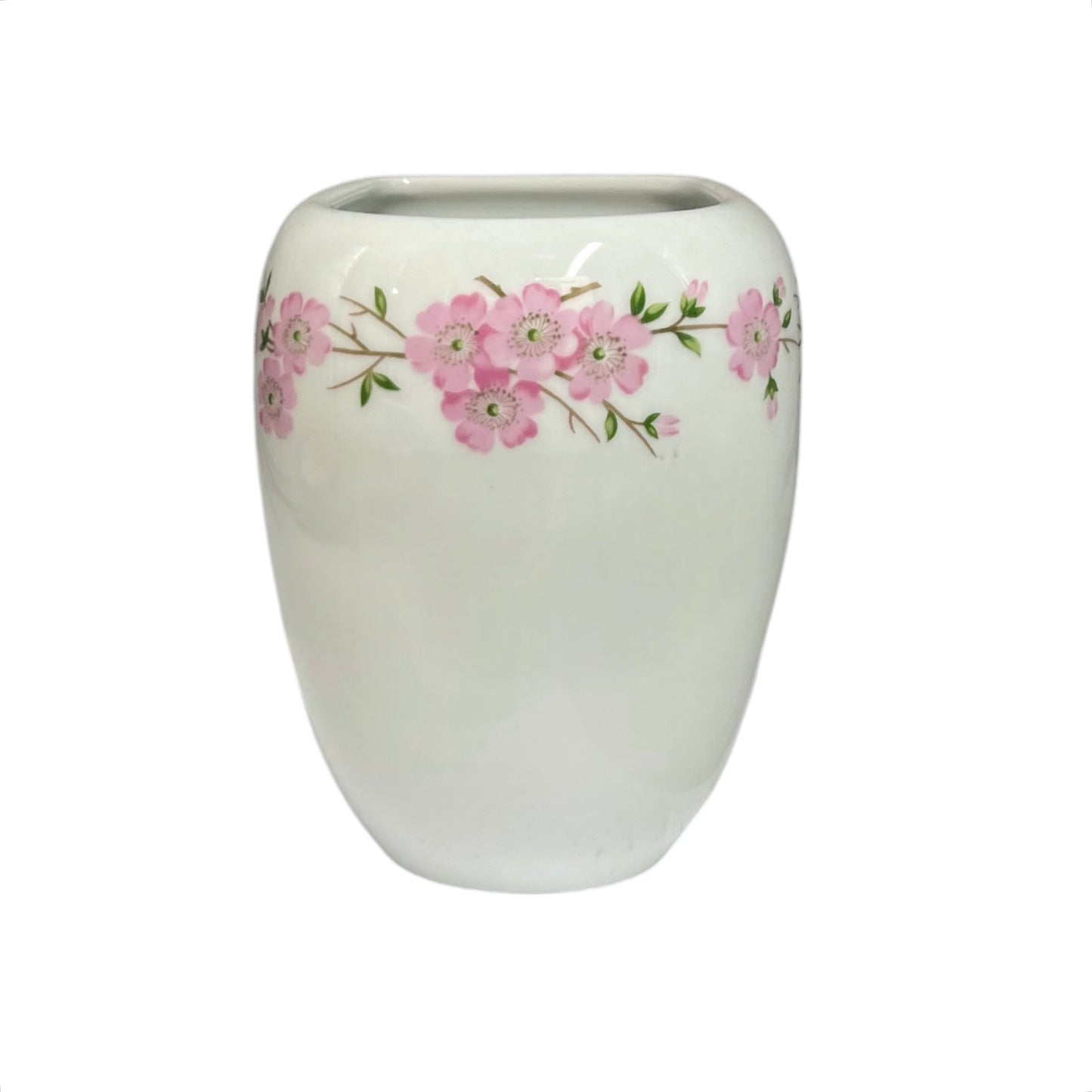 A glossy white porcelain toothbrush pot decorated with a pink cherry blossom pattern around the upper half, shown against a plain white background.
