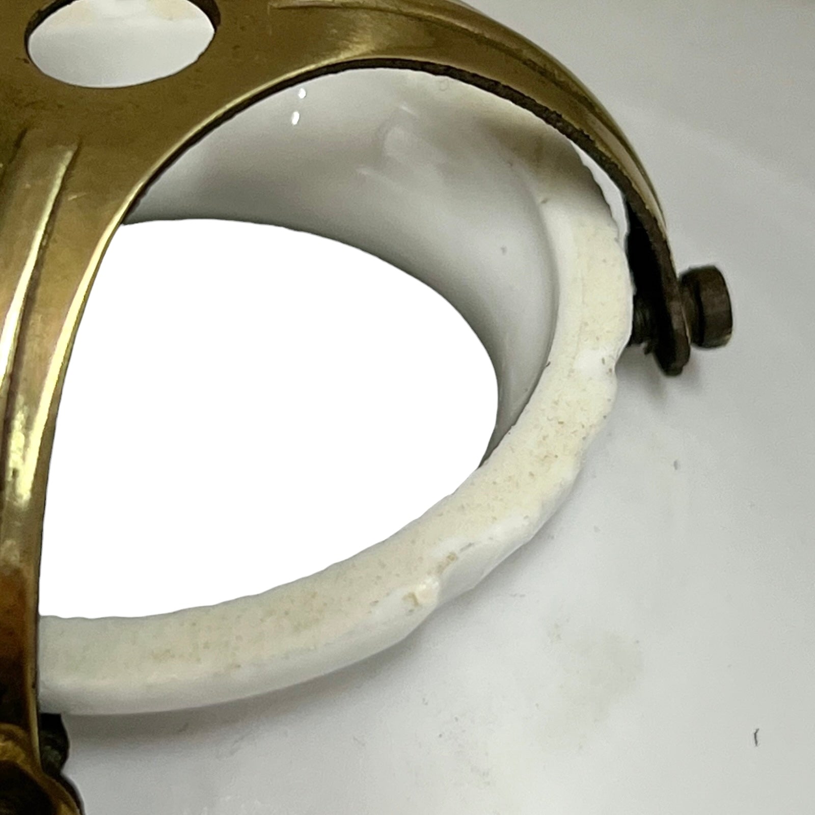 Close-up of a brass and ceramic ring on a white background