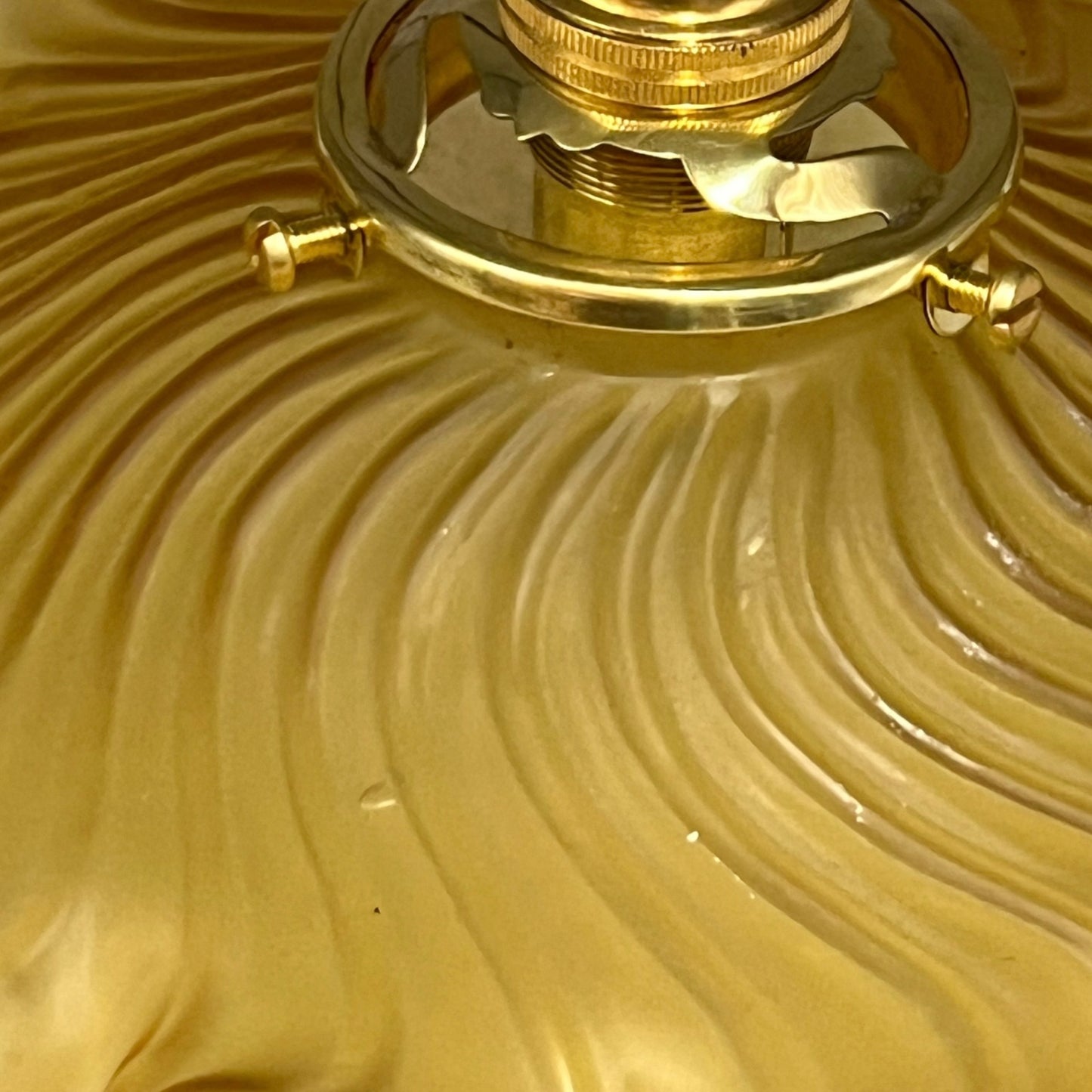 close up of amber coloured vintage French  pendant light with a scalloped design on a white background