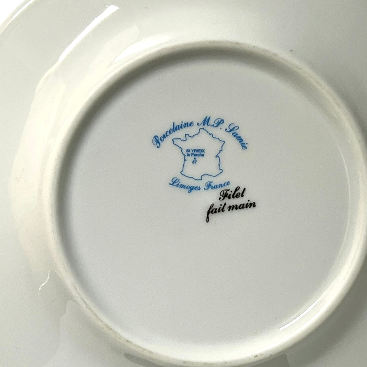 Ceramic plate with blue and black text on a white background