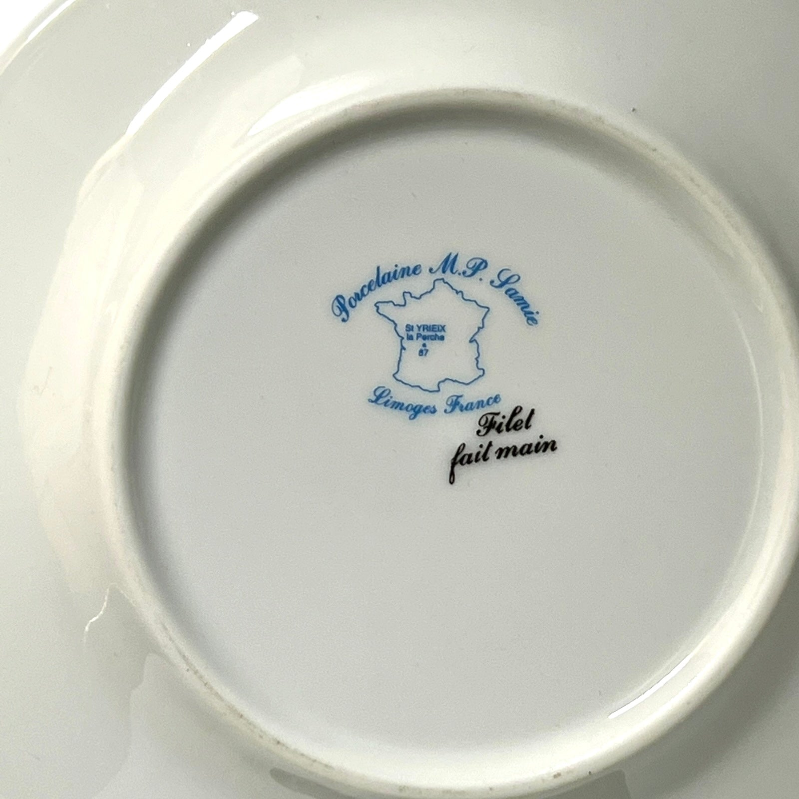 Ceramic plate with blue and black text on a white background
