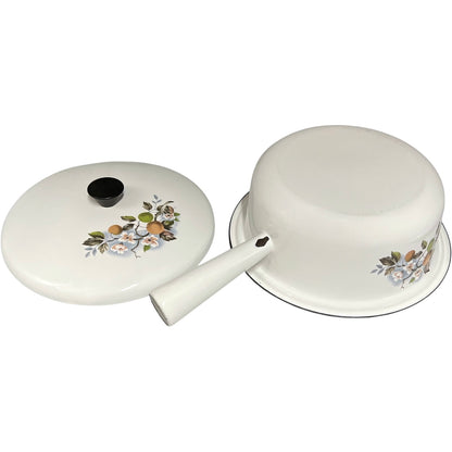 White enamel saucepan and lid with floral design on a white background