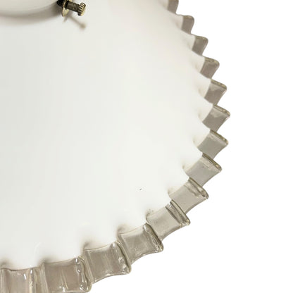Close-up of a milk-glass frilled-edge lampshade against a white background.