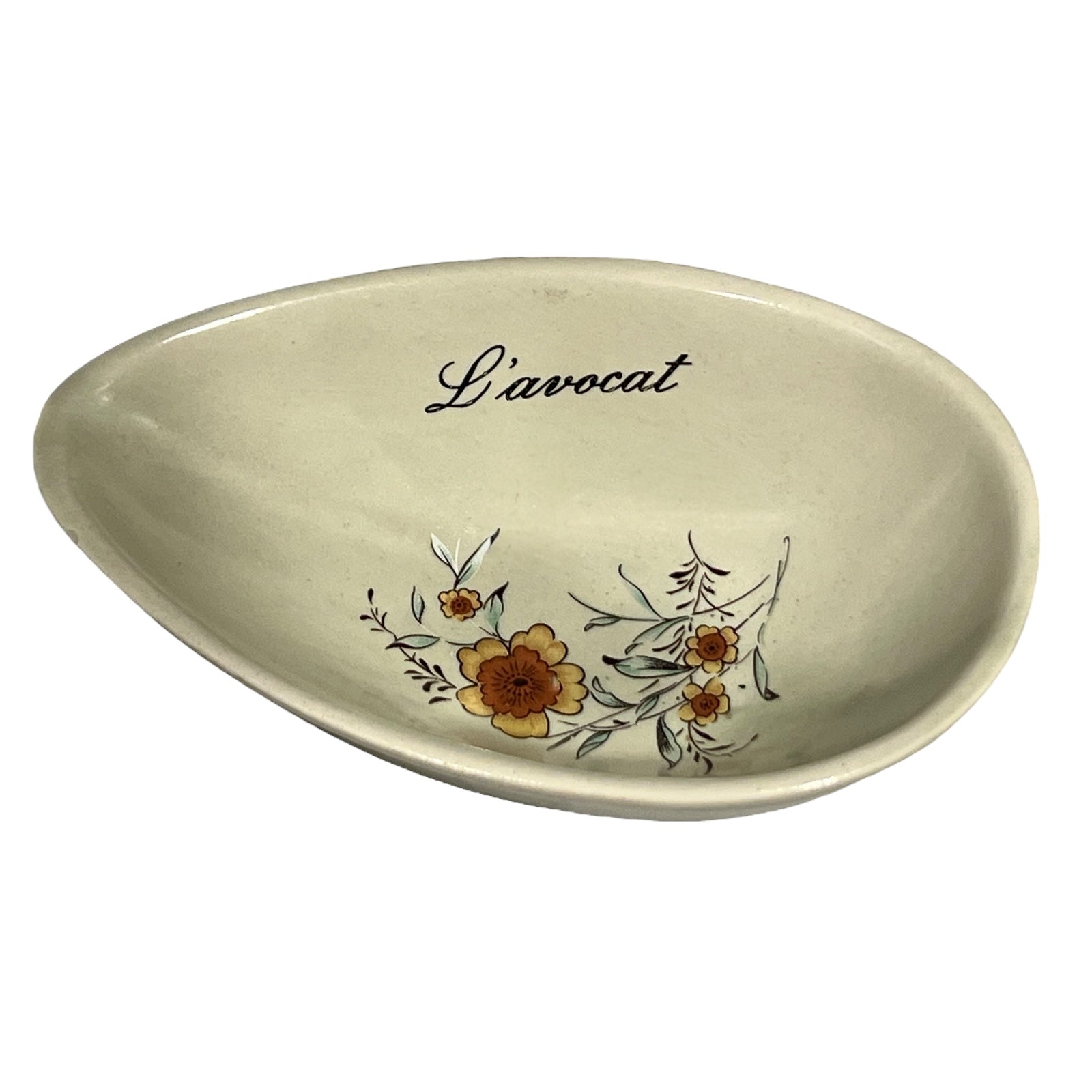 Beige ceramic dish with floral design and 'L'avocat' text on a white background