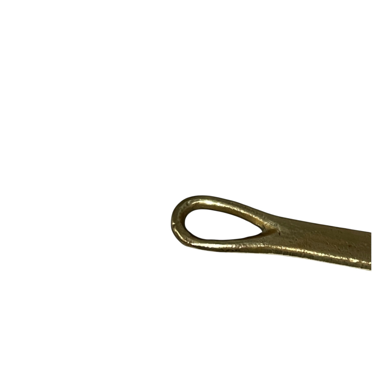 A close-up of a brass pan handle on a plain white background.