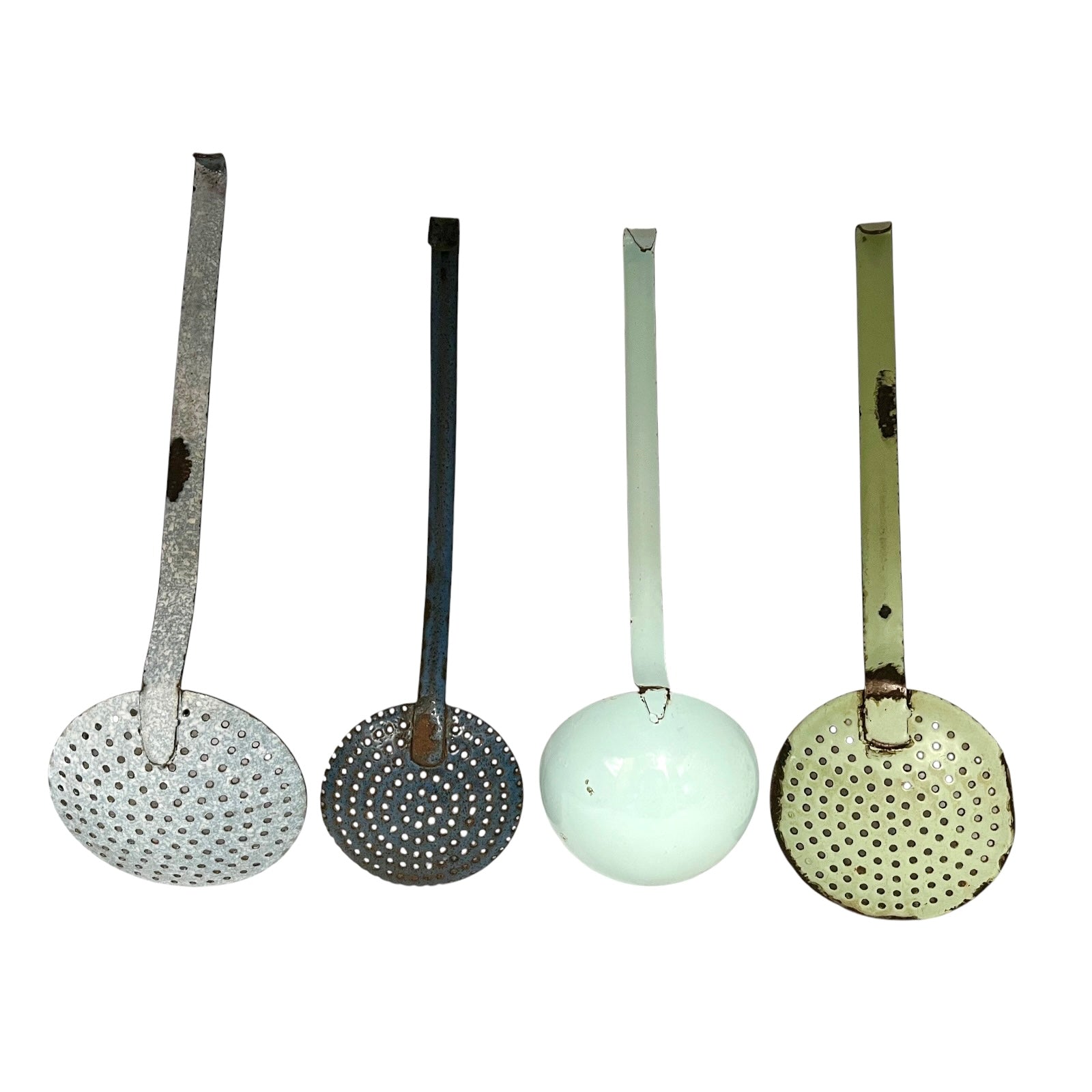 Four vintage metal kitchen ladles with perforated strainers are lined up horizontally against a plain white background. The ladles have long handles and round bowls, showing different colors and finishes: silver, dark gray, pale mint green, and olive green.