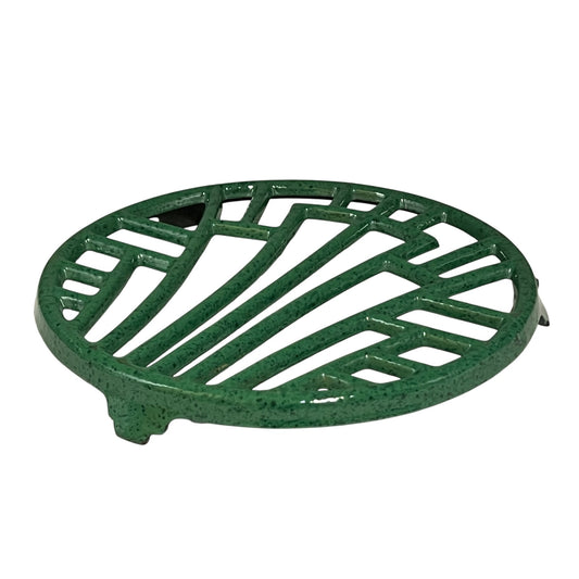 Green vintage French cast iron enamelled pan trivet on a white background
