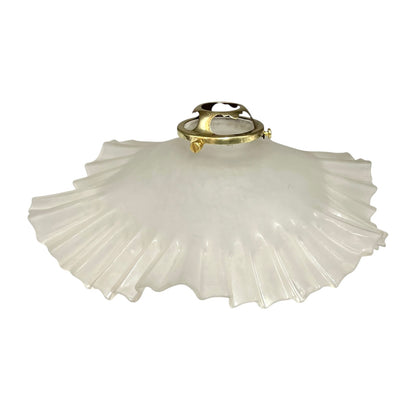 White pleated lampshade with brass fitting on a white background