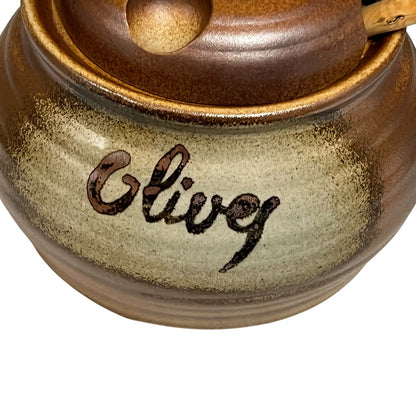 Close-up of a ceramic container with 'Olive' engraved on it, on a white background.