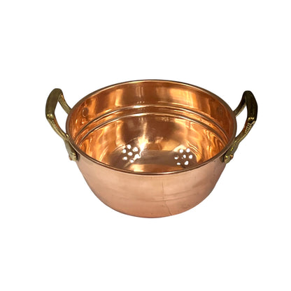 A copper colander with two brass handles and a perforated bottom, shown on a plain white background.