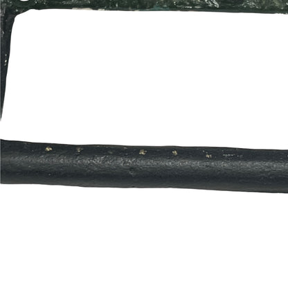 A close-up of a black textured cylindrical product, likely a strap, trim, or cable, with a white background.
