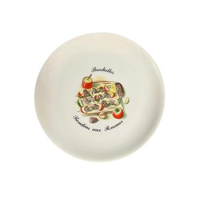 Round ceramic plate with decorative fruit illustration on a white background