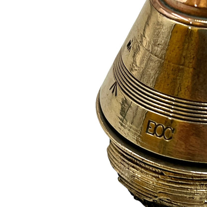 Close up of a polished British brass WW1 fuse or paperweight type 101 on a white background