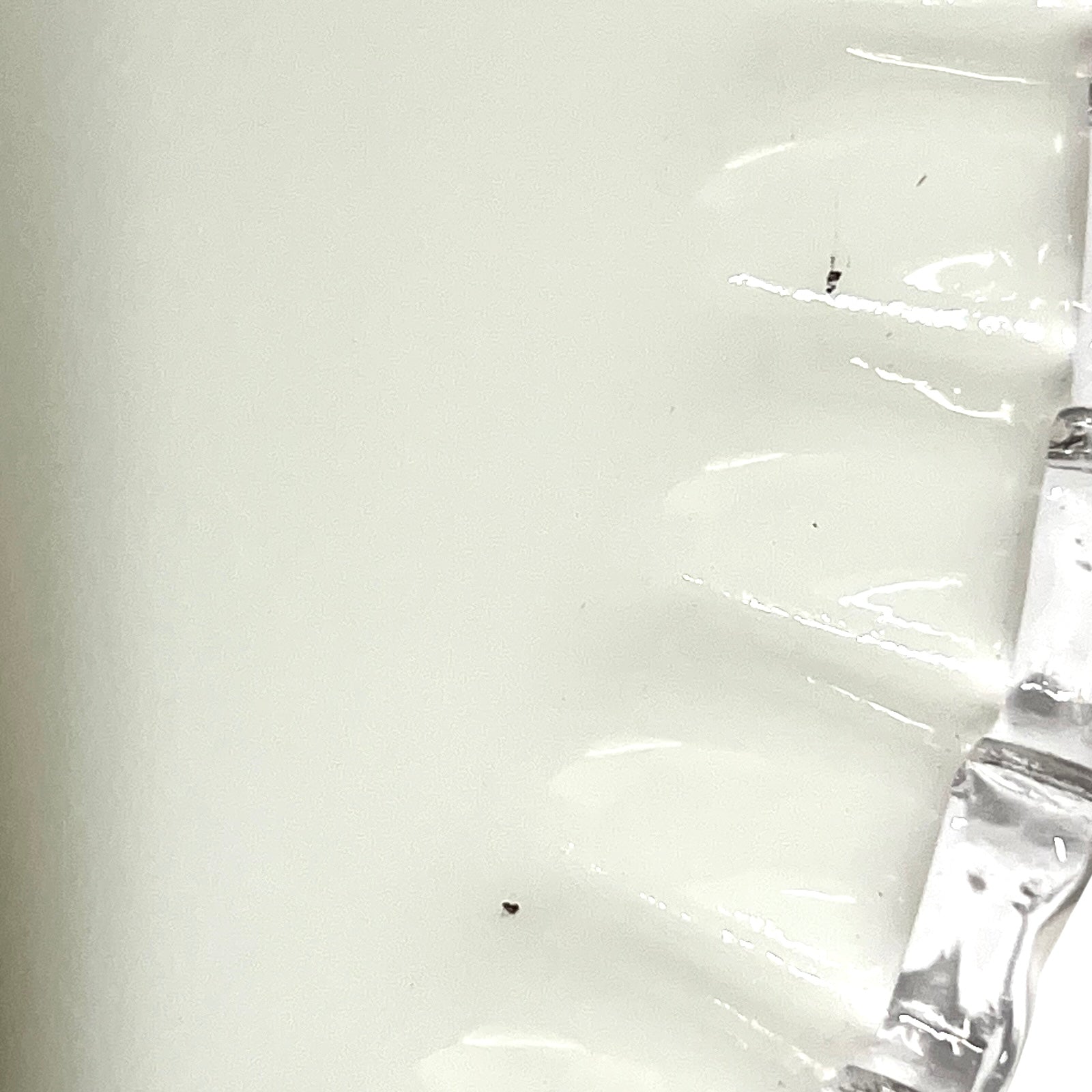 close up of white glass lampshade with a pleated edge