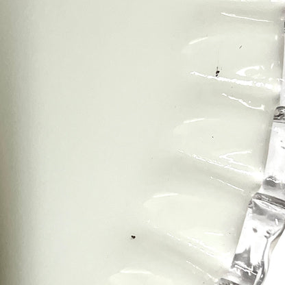 close up of white glass lampshade with a pleated edge