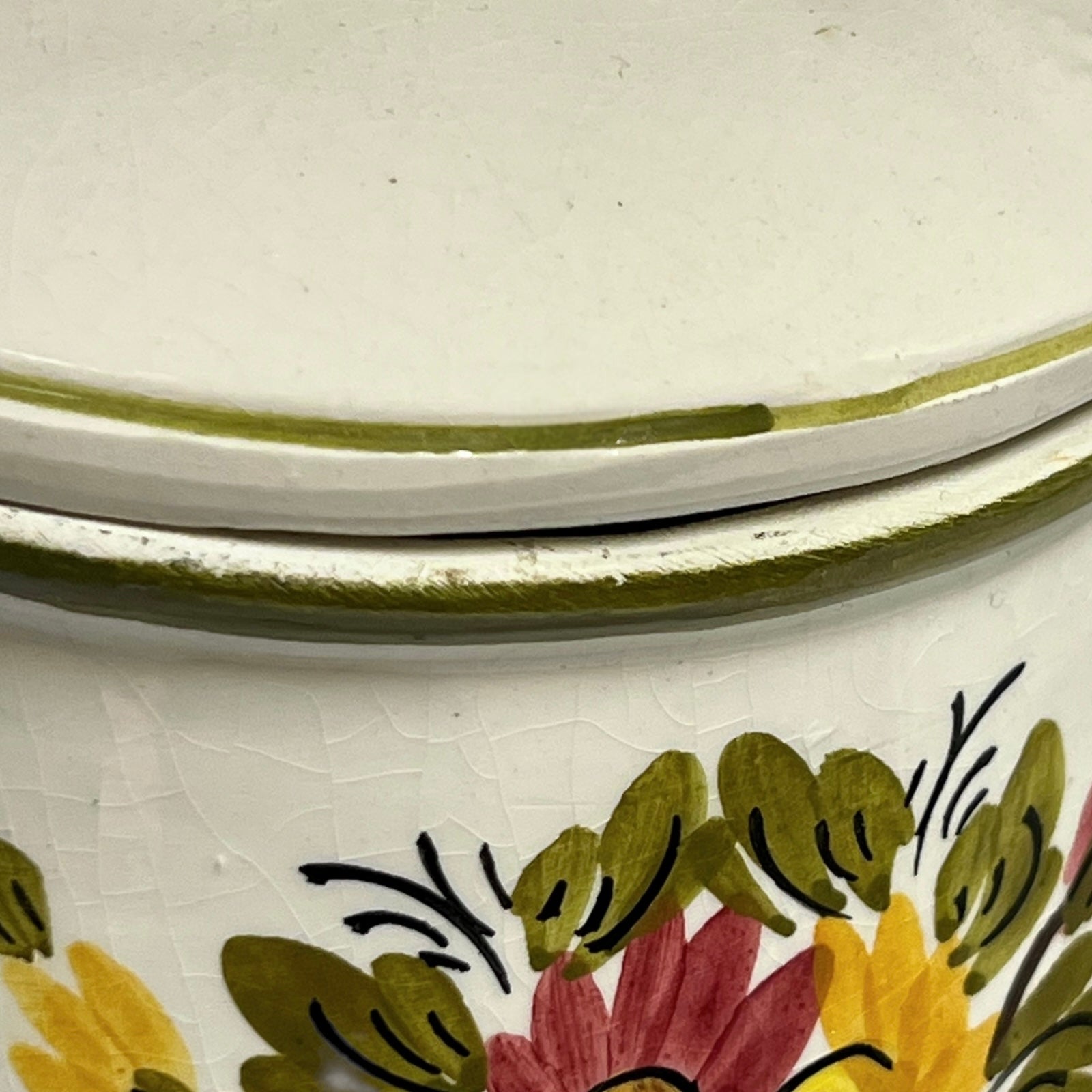 Close-up of a ceramic container with floral patterns and gold accents.