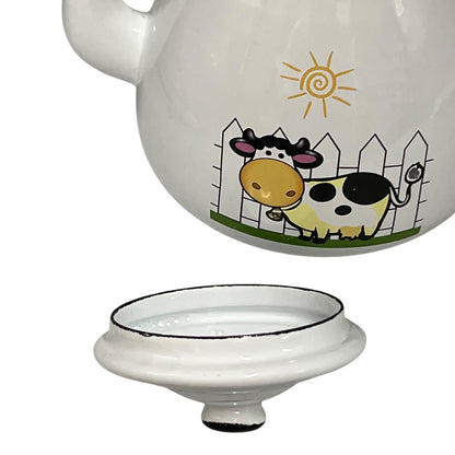 Enamel tea pot with a cow illustration on a white background