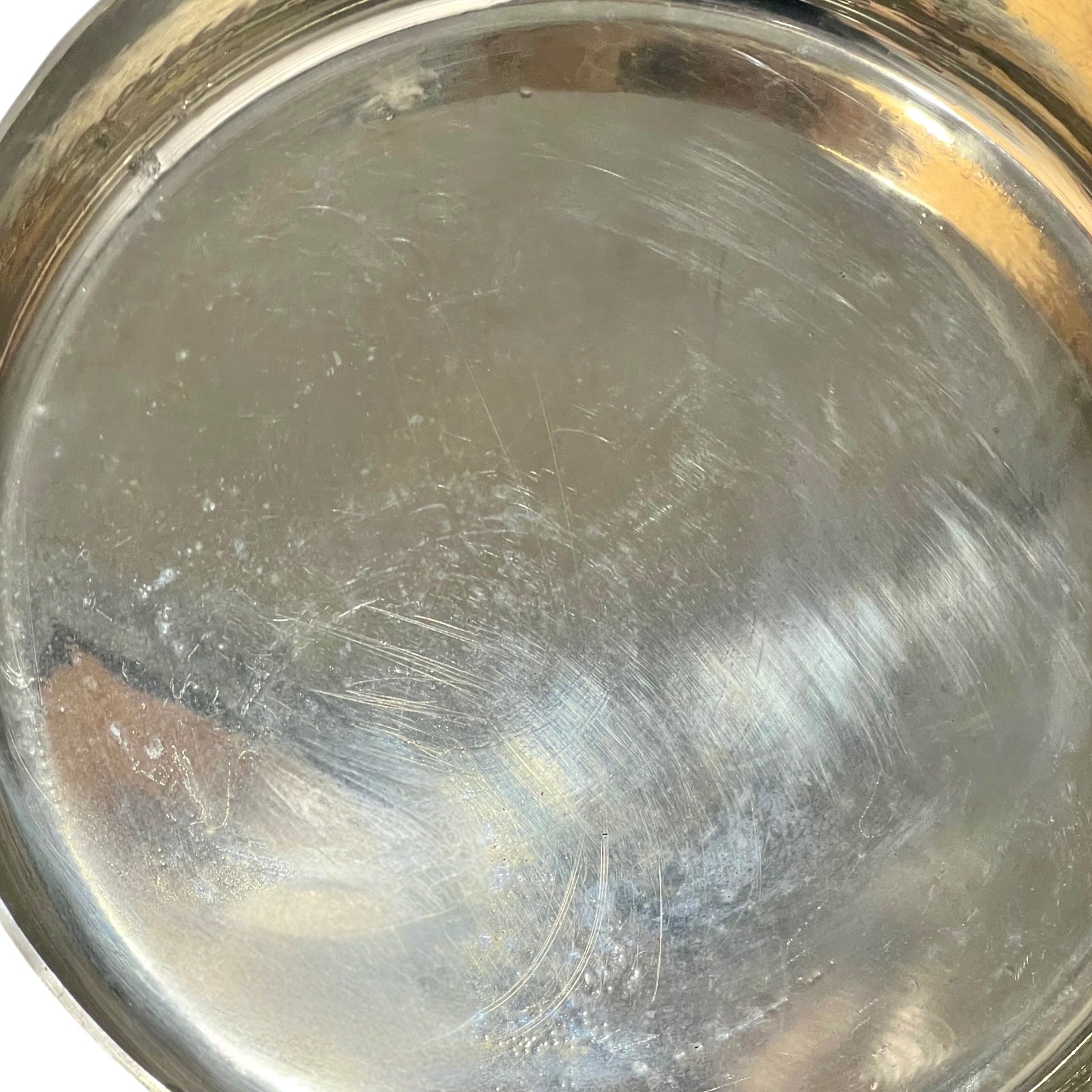 Inside tin lining of a copper saute pan  on a white background