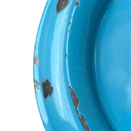 Close up of blue metal bucket with a wooden handle on a white background