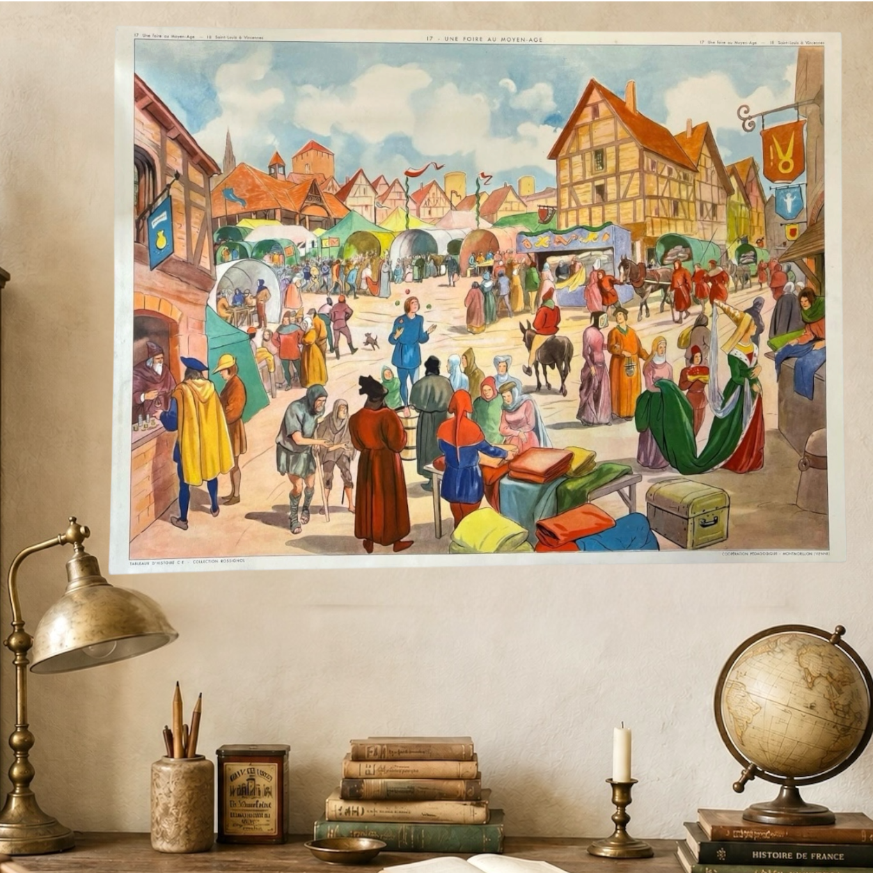 Decorative wall art of a historical marketplace scene on a wall above a desk with books and a globe.