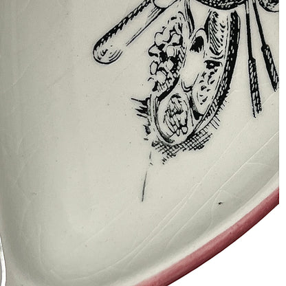 Close-up of a vintage fondue plate with detailed design on a white background