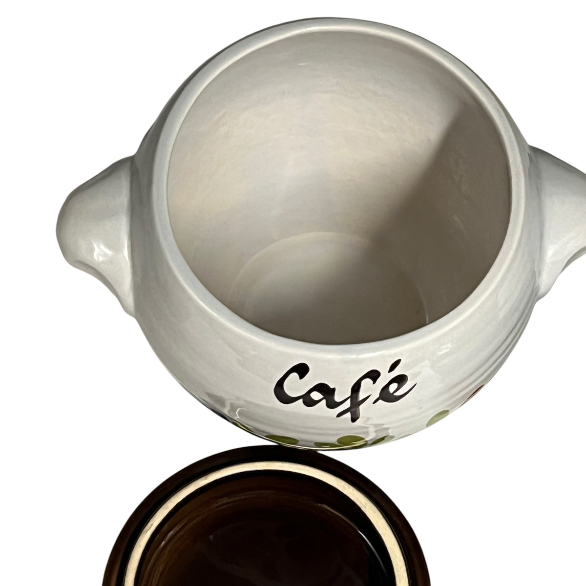 A white ceramic sugar bowl with side handles and the word 'Café' printed in black script, shown with its dark brown lid placed below on a white background.