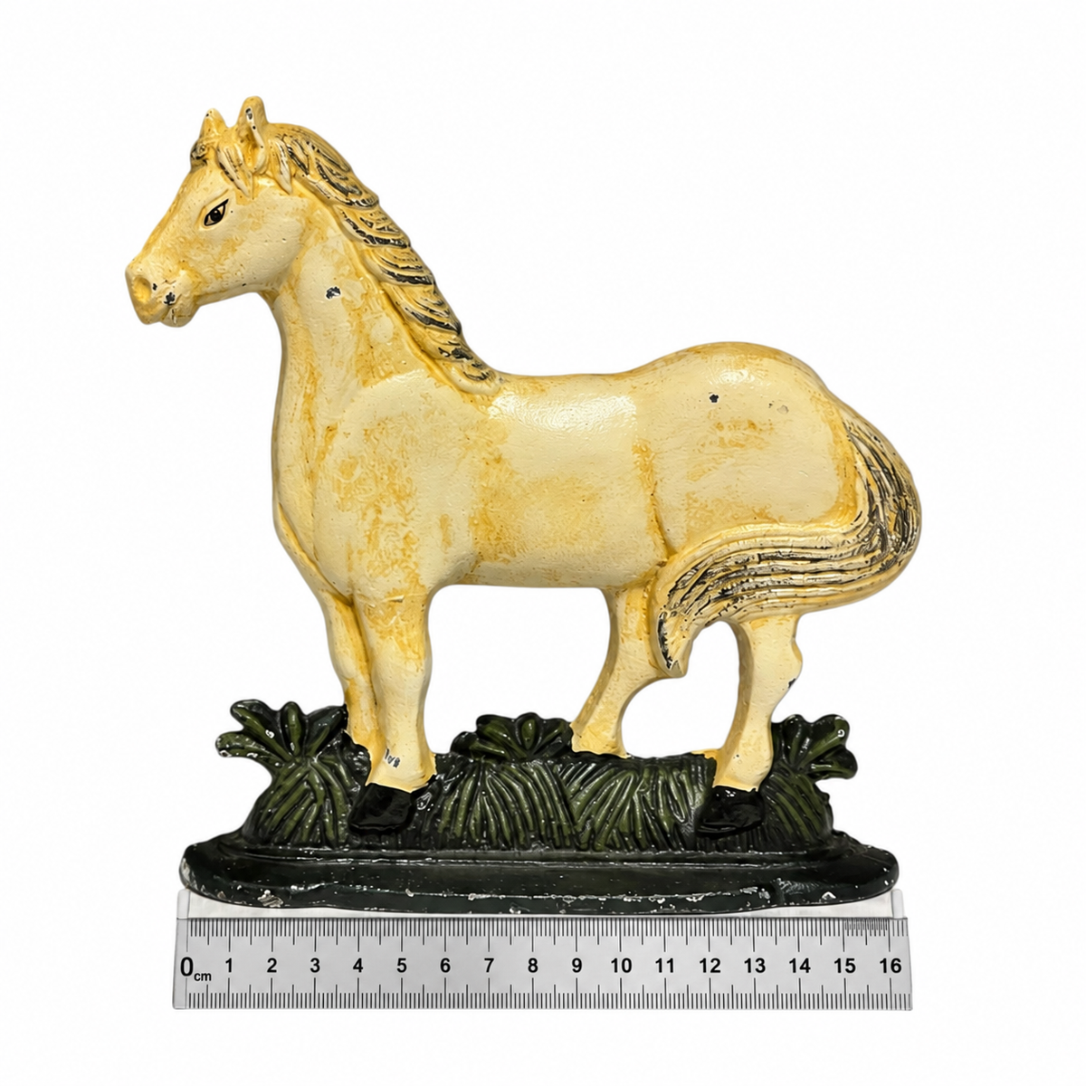 A vintage-style cast iron horse figurine doorstop standing on a dark decorative base with a ruler underneath to show scale, photographed against a white background.