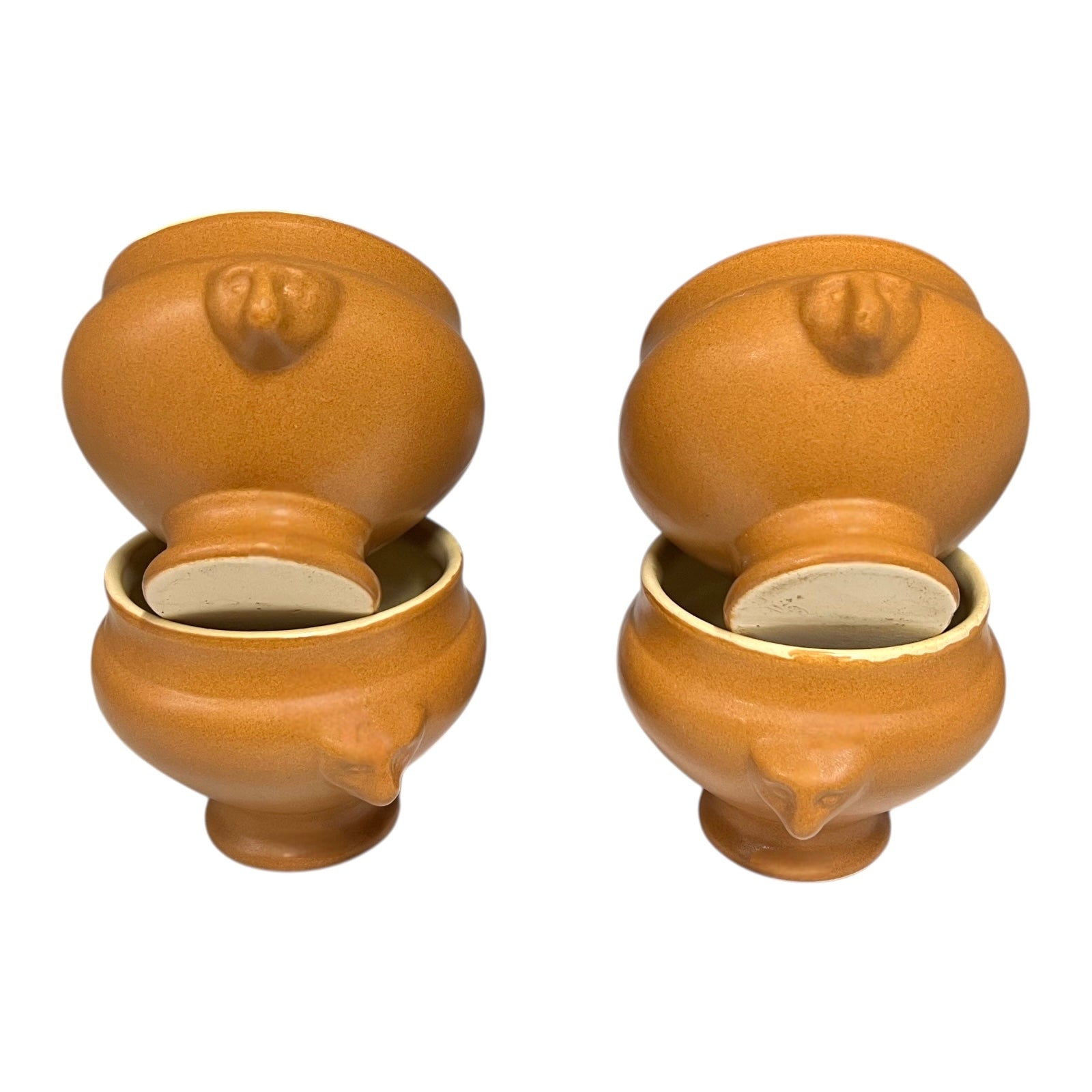 Set of four light brown ceramic French soup bowls with lions head handles on a white background for sale from All Things French Store